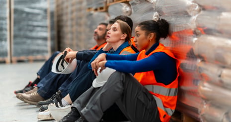 exhausted-warehouse-workers-resting-during-a-hard-2026-03-26-23-22-01-utc